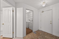 Foyer featuring a textured ceiling, washing machine and dryer, and light floors - 