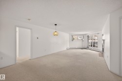 Carpeted spare room with a textured ceiling, a fireplace, and a baseboard heating unit - 