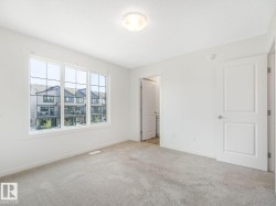 Unfurnished bedroom featuring light carpet and baseboards - 