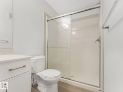 Bathroom with vanity, a shower stall, and light wood-style floors - 