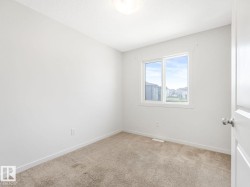 Spare room featuring light carpet and baseboards - 