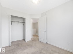 Unfurnished bedroom featuring light colored carpet, a closet, and a textured ceiling - 