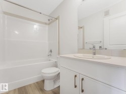 Bathroom featuring shower / tub combination, vanity, light wood-type flooring, and a textured ceiling - 