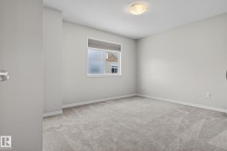 Empty room with a textured ceiling and light colored carpet - 