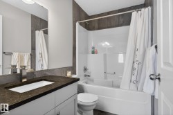 Full bath with a textured ceiling, shower / tub combo, and vanity - 