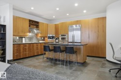 Kitchen featuring open shelves, an island with sink, appliances with stainless steel finishes, modern cabinets, and a kitchen breakfast bar - 