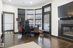 Office featuring a glass covered fireplace, dark wood-style floors, and recessed lighting - 