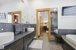 Bathroom featuring double vanity, a tub, ensuite bath, and tiled shower - 