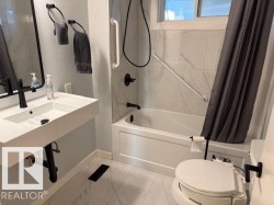 Bathroom featuring shower / bathtub combination with curtain and light marble finish floors - 