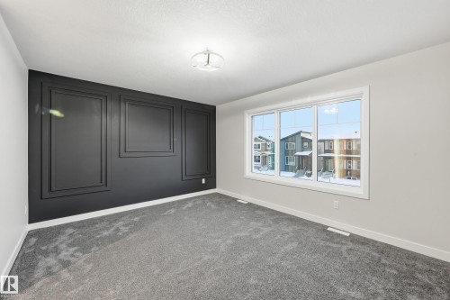 Empty room featuring baseboards and dark carpet - 53 Patriot Way, Spruce Grove, AB - Indoor Photo Showing Other Room