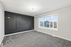 Empty room featuring baseboards and dark carpet - 