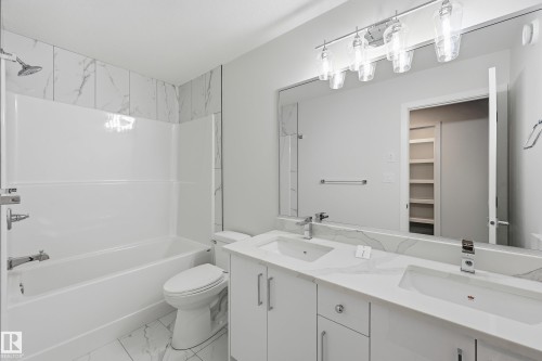 Full bathroom with double vanity, shower / washtub combination, light marble finish floors, and a walk in closet - 53 Patriot Way, Spruce Grove, AB - Indoor Photo Showing Bathroom