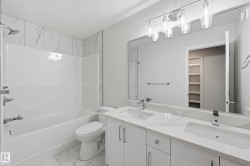 Full bathroom with double vanity, shower / washtub combination, light marble finish floors, and a walk in closet - 