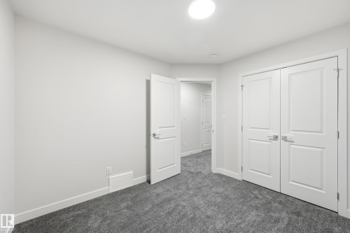 Unfurnished bedroom with dark colored carpet and a closet - 53 Patriot Way, Spruce Grove, AB - Indoor Photo Showing Other Room