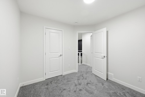 Unfurnished bedroom featuring carpet and baseboards - 53 Patriot Way, Spruce Grove, AB - Indoor Photo Showing Other Room
