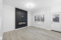 Foyer entrance with a large fireplace and light wood-style floors - 