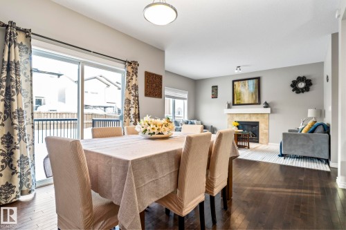 Dining room with a tile fireplace and dark wood-style floors - 5734 175A Avenue, Edmonton, AB - Indoor Photo Showing Dining Room With Fireplace