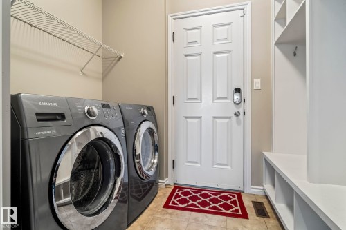 Laundry area featuring light tile patterned floors and washing machine and clothes dryer - 5734 175A Avenue, Edmonton, AB - Indoor Photo Showing Laundry Room