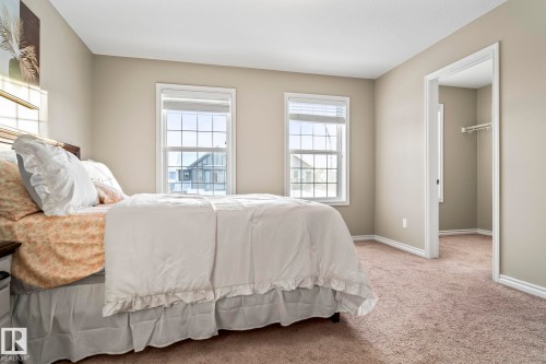 Bedroom featuring light colored carpet and a walk in closet - 5734 175A Avenue, Edmonton, AB - Indoor Photo Showing Bedroom