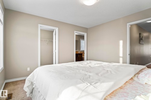 Bedroom featuring carpet, a walk in closet, and multiple windows - 5734 175A Avenue, Edmonton, AB - Indoor Photo Showing Bedroom