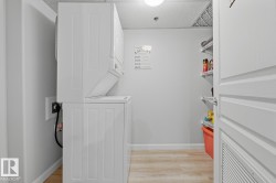 Laundry room featuring stacked washing machine and dryer and light wood finished floors - 