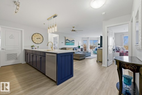 Kitchen featuring hanging light fixtures, a peninsula, dishwasher, open floor plan, and ceiling fan - 314 530 Hooke Road, Edmonton, AB - Indoor Photo Showing Kitchen