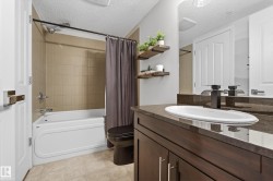 Bathroom featuring vanity, a textured ceiling, and shower / bathtub combination with curtain - 