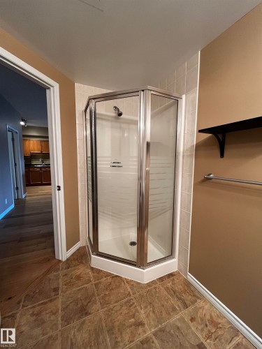 Full bath with a shower stall and dark tile patterned floors - 405 10319 111 Street, Edmonton, AB - Indoor Photo Showing Bathroom