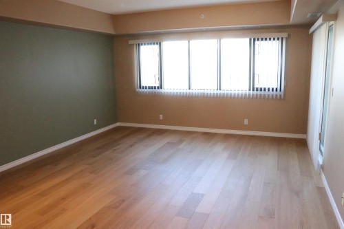 Living room featuring light wood-type flooring and baseboards - 405 10319 111 Street, Edmonton, AB - Indoor Photo Showing Other Room