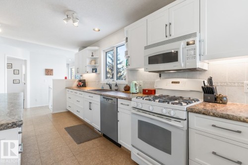 Kitchen with white appliances, white cabinets, open shelves, and recessed lighting - 6508 109 Avenue, Edmonton, AB - Indoor Photo Showing Kitchen