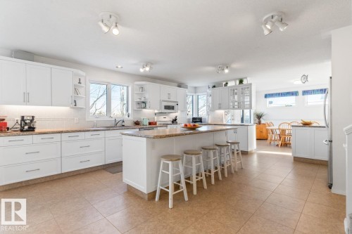 Kitchen with white cabinetry, a kitchen breakfast bar, open shelves, and a kitchen island - 6508 109 Avenue, Edmonton, AB - Indoor Photo Showing Kitchen With Upgraded Kitchen