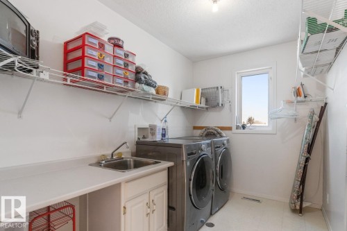 Laundry room with light flooring, washer and clothes dryer, and a textured ceiling - 6508 109 Avenue, Edmonton, AB - Indoor Photo Showing Laundry Room