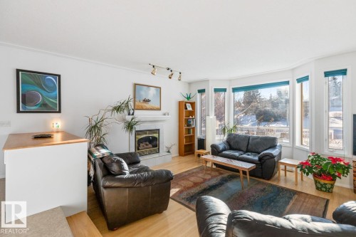 Living area featuring light wood-type flooring and a tile fireplace - 6508 109 Avenue, Edmonton, AB - Indoor Photo Showing Living Room With Fireplace