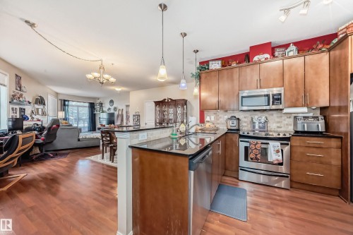 100 9940 Sherridon Drive, Fort Saskatchewan, AB - Indoor Photo Showing Kitchen With Stainless Steel Kitchen With Double Sink With Upgraded Kitchen