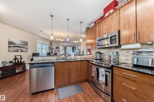 100 9940 Sherridon Drive, Fort Saskatchewan, AB - Indoor Photo Showing Kitchen With Stainless Steel Kitchen