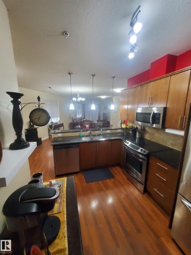 100 9940 Sherridon Drive, Fort Saskatchewan, AB - Indoor Photo Showing Kitchen With Stainless Steel Kitchen