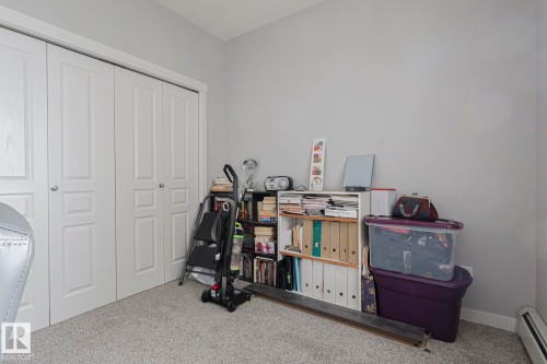Recreation room with carpet floors and a baseboard radiator - 407 812 Welsh Drive, Edmonton, AB - Indoor