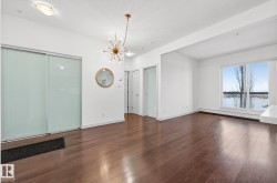 Empty room featuring a chandelier, dark wood-style floors, and a baseboard heating unit - 