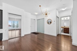 Interior space with a chandelier and dark wood-style floors - 