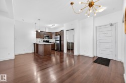 Kitchen with open floor plan, light countertops, a chandelier, and decorative light fixtures - 