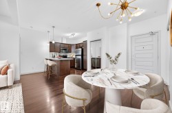 Dining area with a chandelier and dark wood-style flooring - 