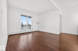 Spare room featuring baseboard heating and dark wood finished floors - 