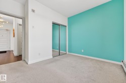 Unfurnished bedroom featuring carpet floors, a closet, a chandelier, and baseboard heating - 