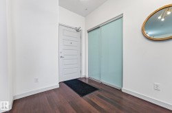 Foyer entrance with dark wood-type flooring and baseboards - 