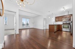 Kitchen with stainless steel appliances, a chandelier, decorative light fixtures, open floor plan, and a peninsula - 