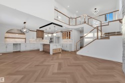 Unfurnished living room featuring a chandelier, a high ceiling, and stairs - 