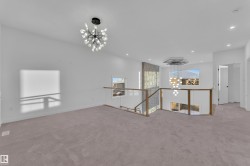 Empty room featuring a chandelier, light carpet, and recessed lighting - 