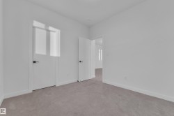 Unfurnished bedroom with light carpet and baseboards - 