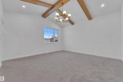 Unfurnished room with light colored carpet, recessed lighting, and a chandelier - 