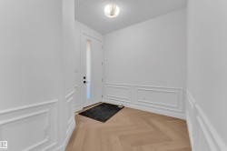 Foyer with parquet floors, a textured ceiling, a decorative wall, and a wainscoted wall - 